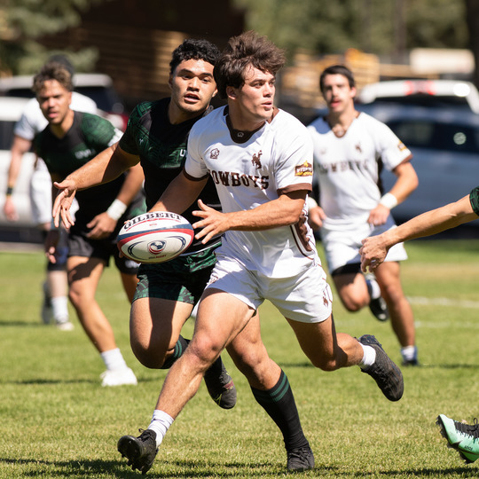 A member of the men's rugby team runs with the ball