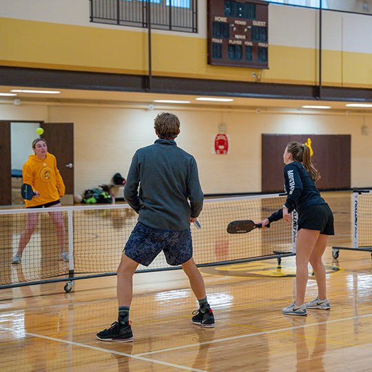 Students play pickleball in the Historic Half Acre Gym