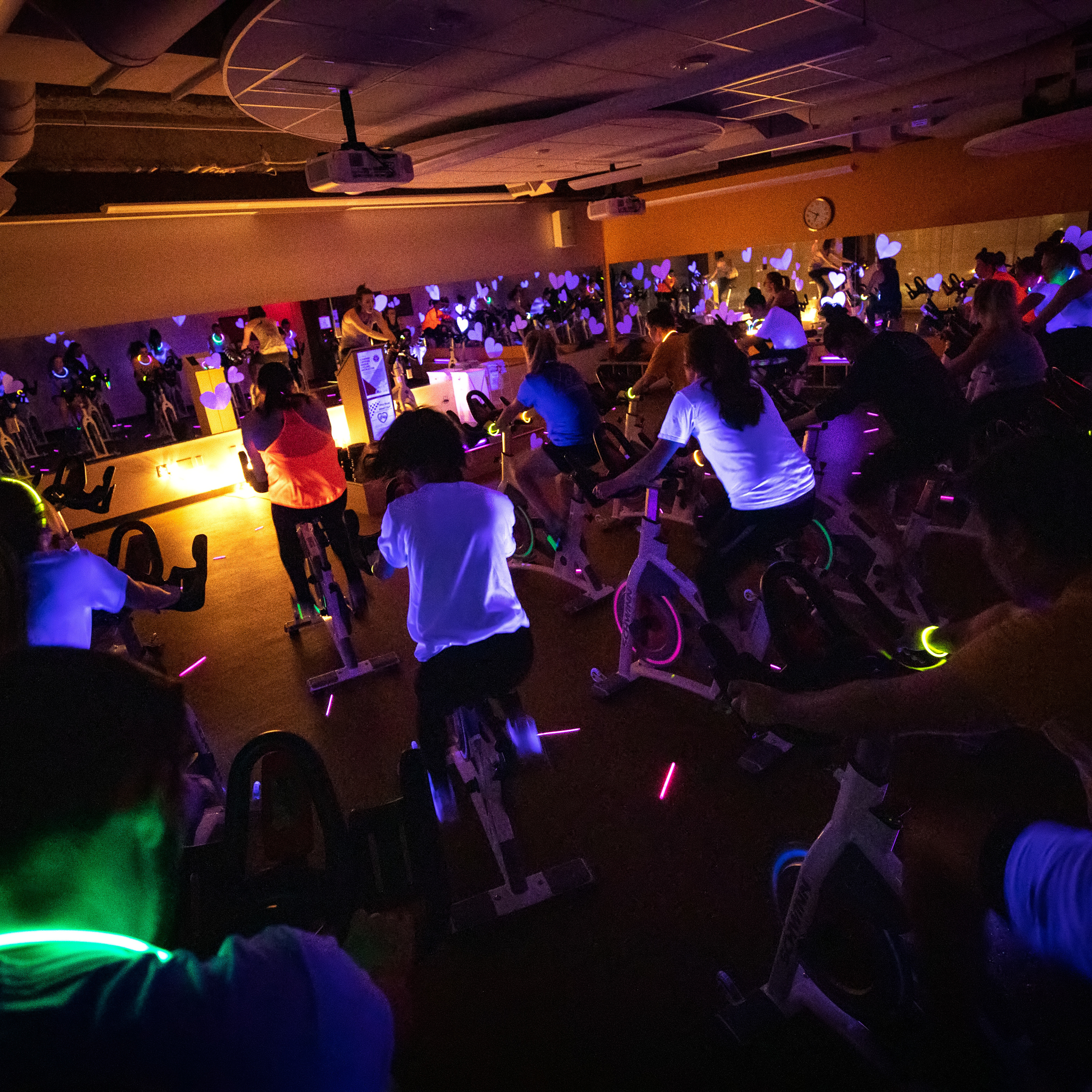 Students take part in a neon spin class