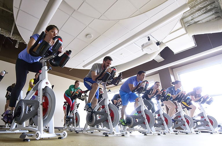 Students participate in a cycling class