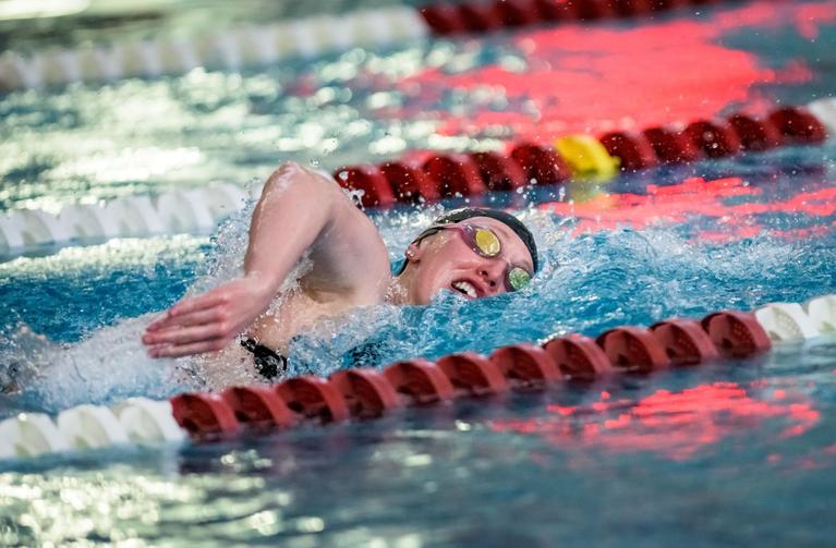 A student swims in the pool at Half Acre