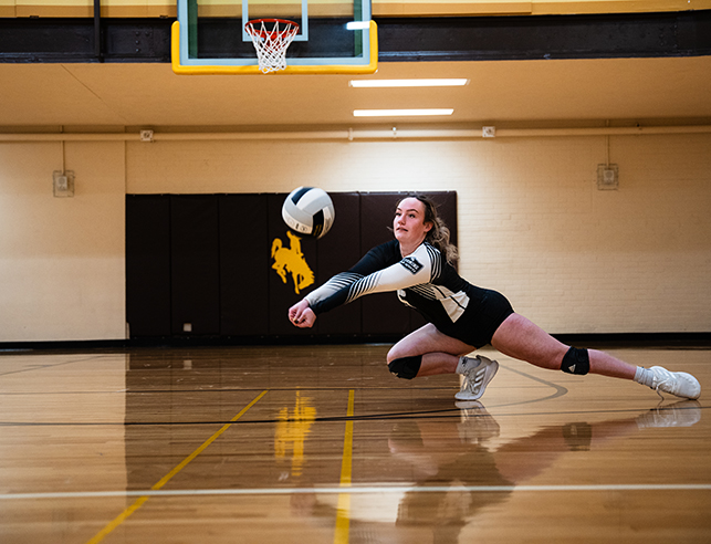 A UW Club volleyball player stretches to make a pass