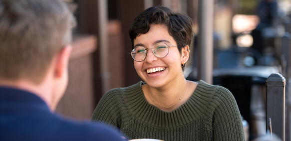 Girl having coffee talking to a friend.