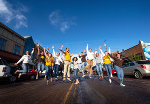 Students jumping for a picture in Downtown Laramie.