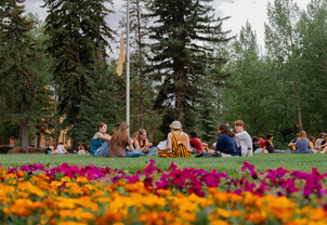 Students sitting and chating with friends in a circle on Prexy's Pasture.