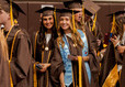 Gilrs standing in line excited for graduation.