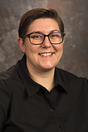 Heidi Reeves-Messner smiling in front of a grey background