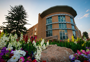 Outside the Half Acre and Wellness Center Building with spring flowers blooming