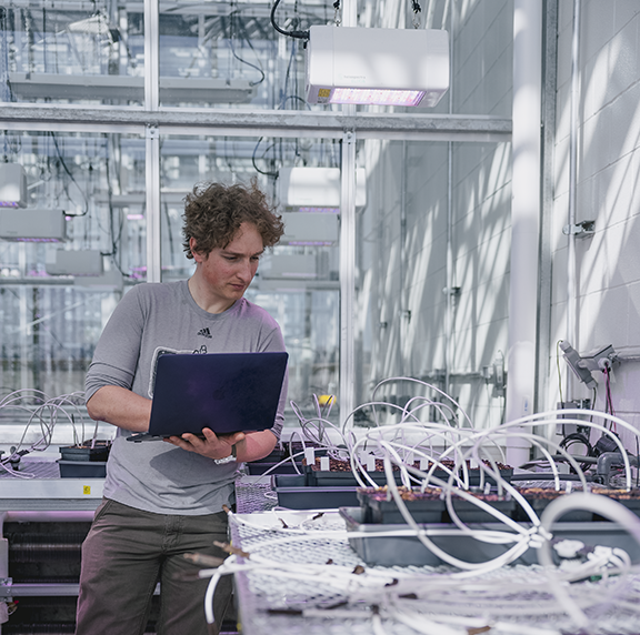 Person with laptop in a tech facility