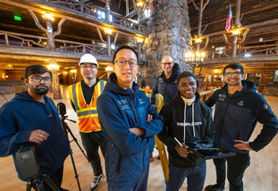 A group of UW community members smile together at a project site.