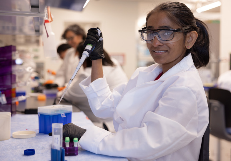 Female researcher in lab holding syringe