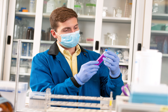 Scientist looking at test tube