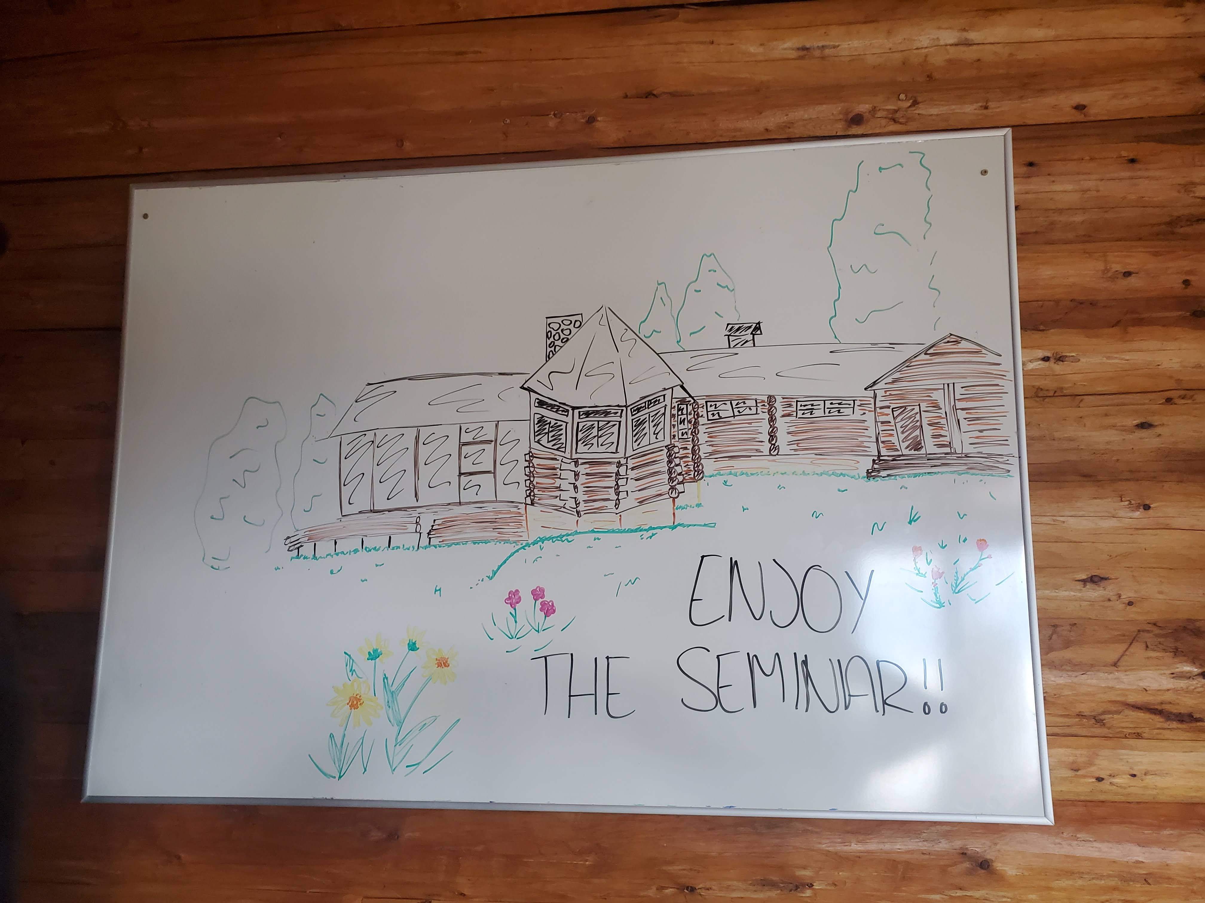 Whiteboard drawing of Berol Lodge that says, "Enjoy the Seminar!"