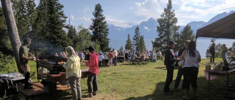 A crowd of people standing out on the lawn outside Berol, getting burgers and enjoying the mountain view