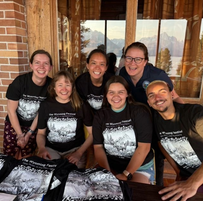 a group of people wearing matching shirts and smiling at the camera