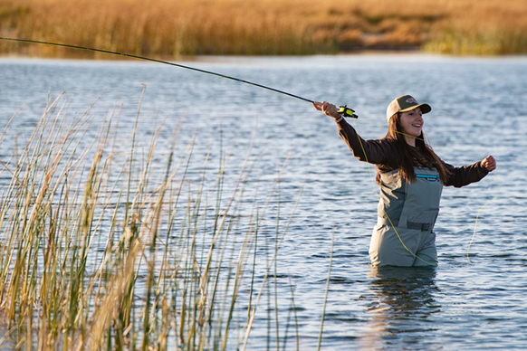 Young woman fly fishing