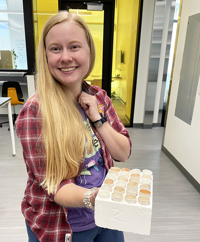 Young female researcher holding an array of crucibles