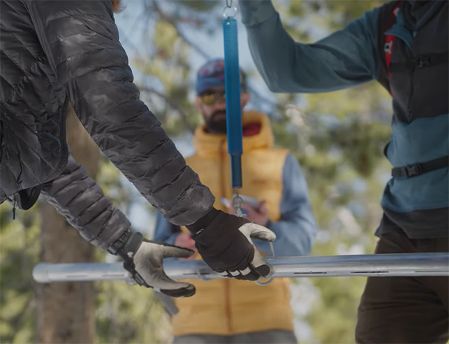 Three researchers measuring snow