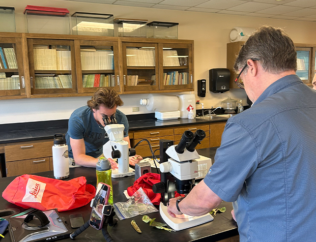 Two men looking in microscopes