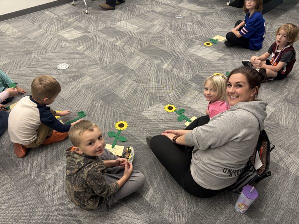 Children and parents on floor with sunflowers