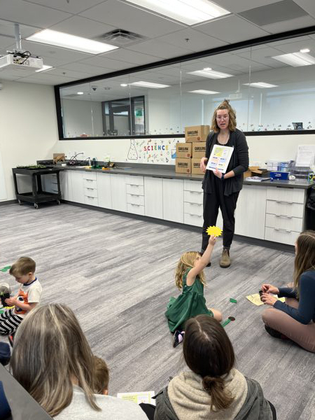 Teacher teaching children sitting on floor