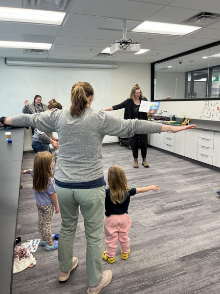 Parents and toddlers with hands out