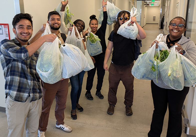 Students holding bags of veggies