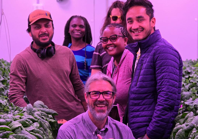 Students and teacher smiling among plants