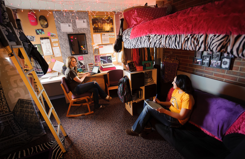 Two students chat while sitting in their dorm room