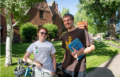 Two students stand together in front of the Honors House