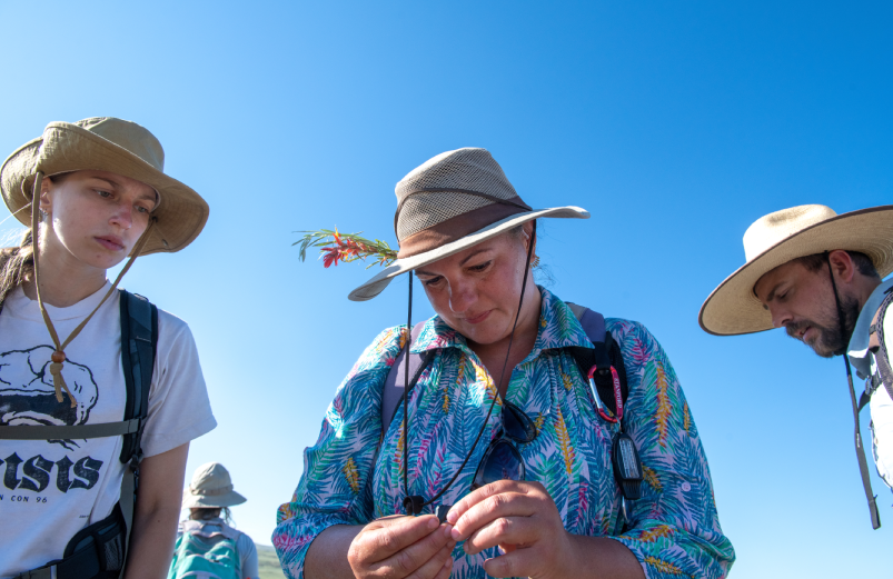 three people looking at an artifact
