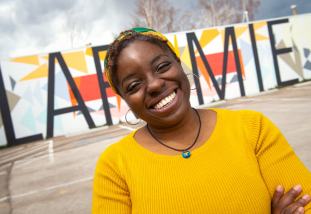 woman smiling in front of the Laramie sign