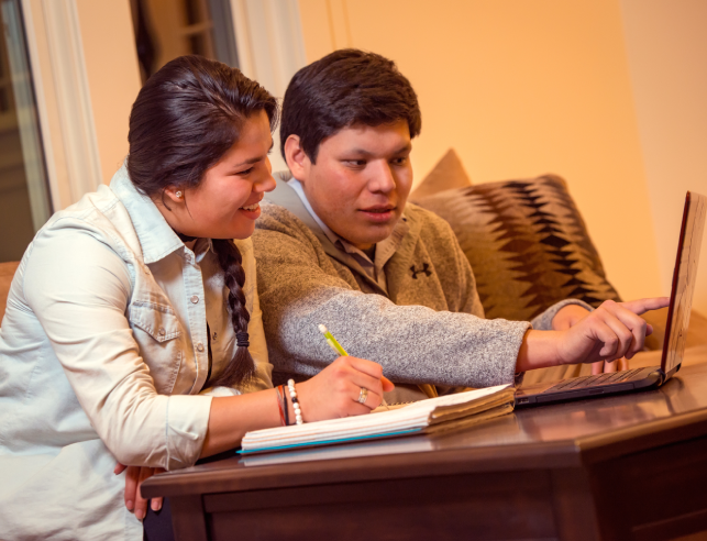 two students looking at a laptop