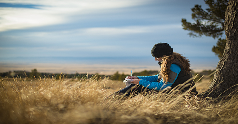 Woman studying by tree
