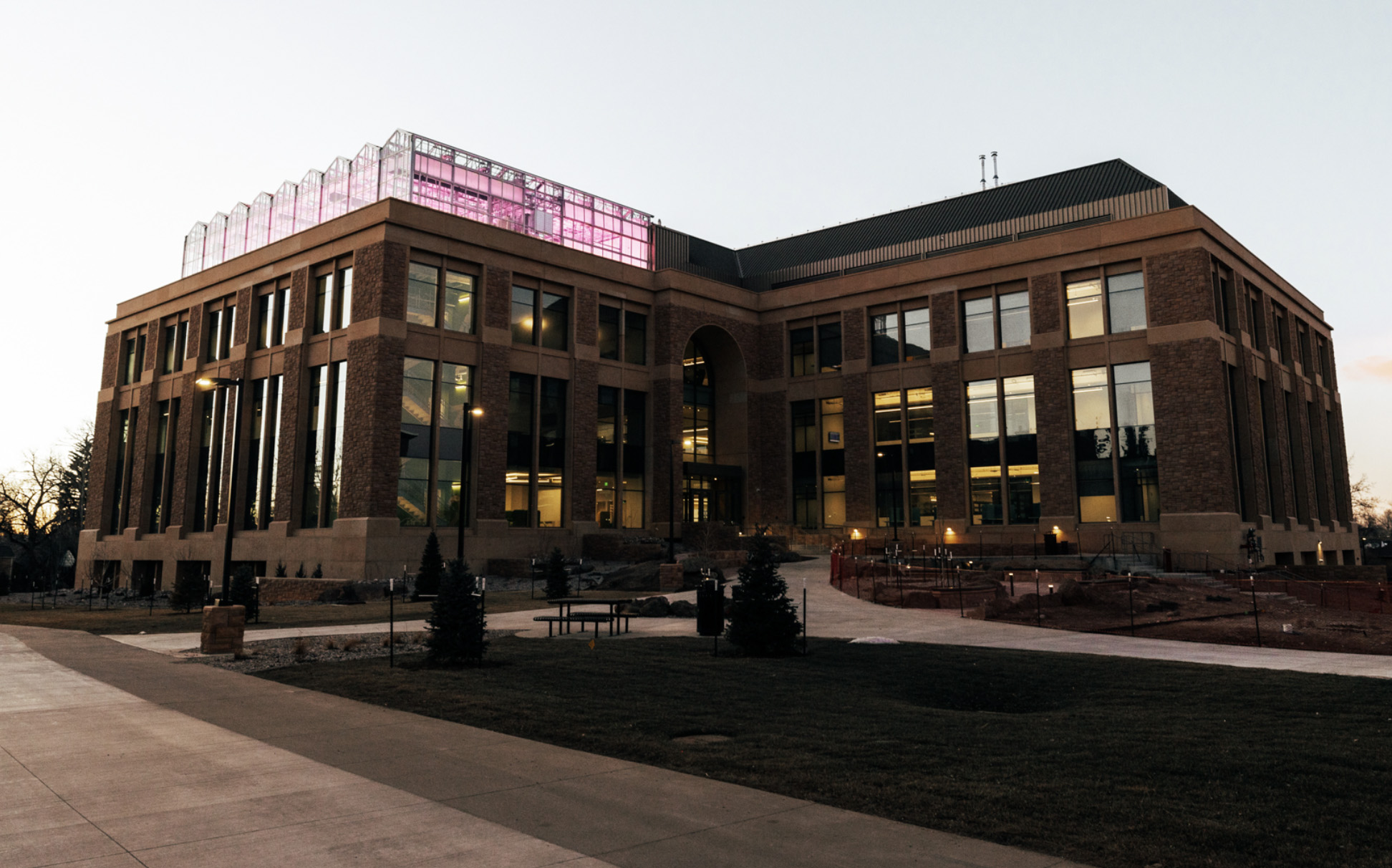 Science building with greenhouse lit up at dusck
