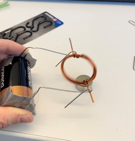 motor with wire, a battery, tape, paperclips, and magnets