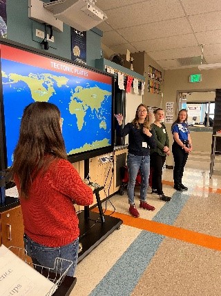 outreach assistants instructing with tectonic plate map
