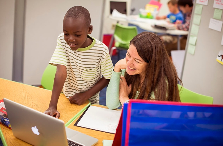 student and instructor working at laptop