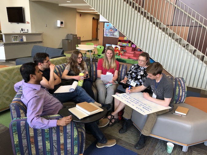 Participants engage in team based learning by collaborating in a seated circle