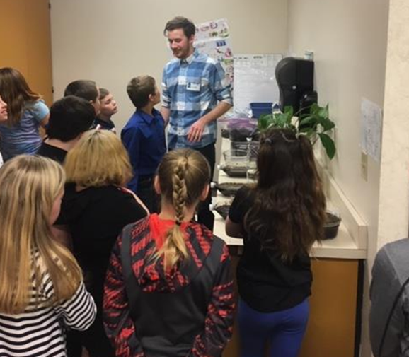 Tyler teaching a group of students about plants