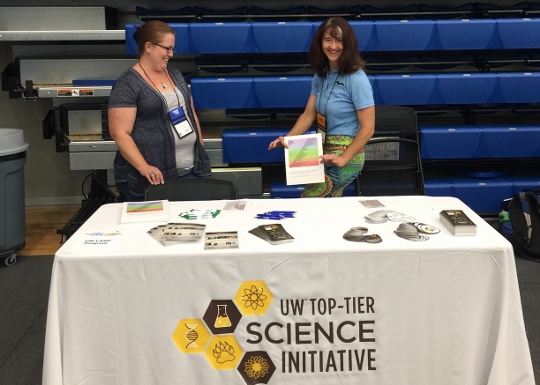 Michelle Larson and Rachel in front of a UW Science Initiative tablecloth