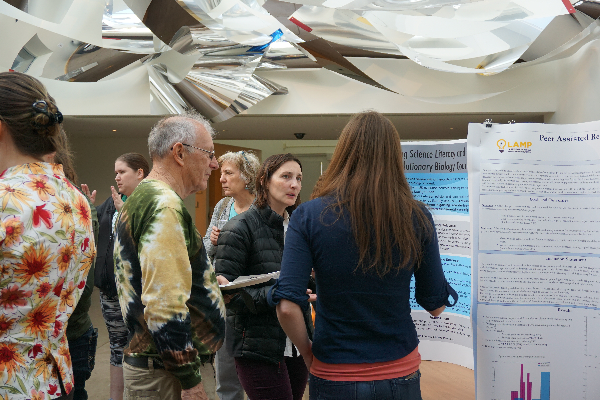 three people talking in front of a poster