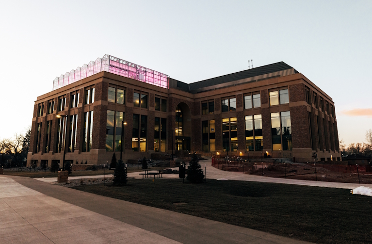 Science Initiative Building and greenhouse lit up in morning light