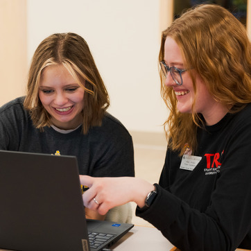 A UW student and a SEO staff member work together on a computer on the University of Wyoming campus.