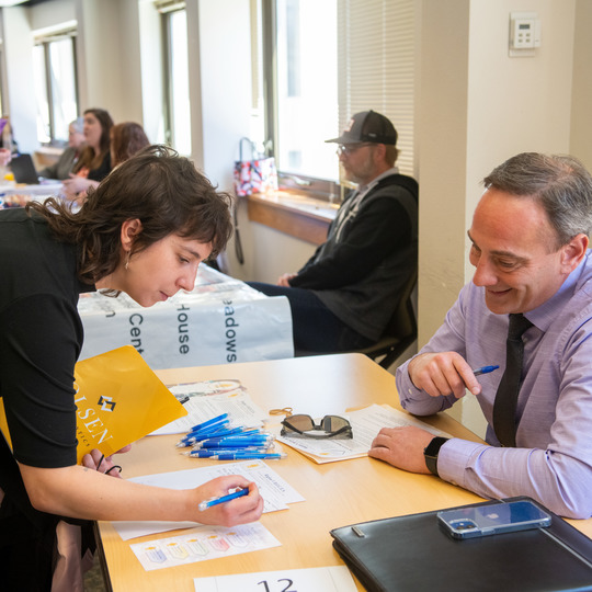 Students signing a paper during a recent career fair.