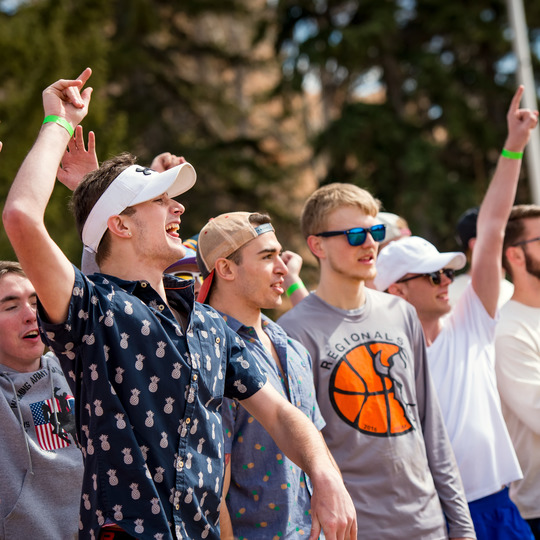 Male students cheering and celebrating outside in Prexy's Pasture. 