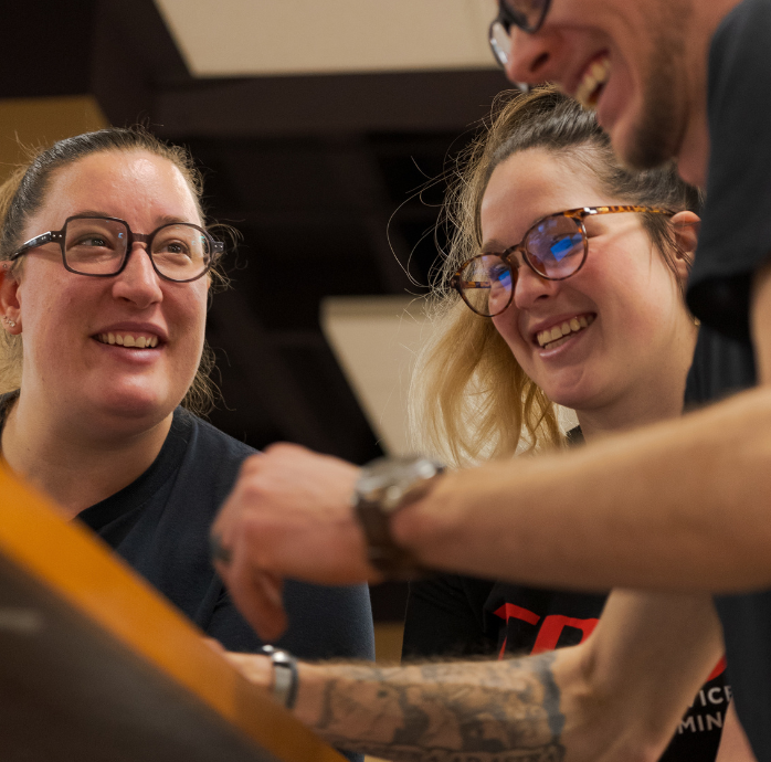 Image of three people working together at a computer.