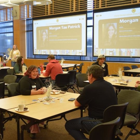 A group of people, including Emilygrace Piel and Paul Hesco of SSS, watch a presentation at the 2023 National First-Generation College Student Celebration Day. 