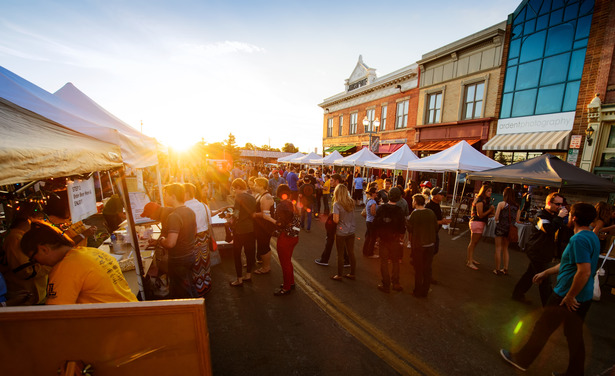 Image of a group of people in downtown Laramie with the sunset on the horizon.