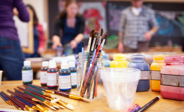 Image of art supplies with people blurred in the background.